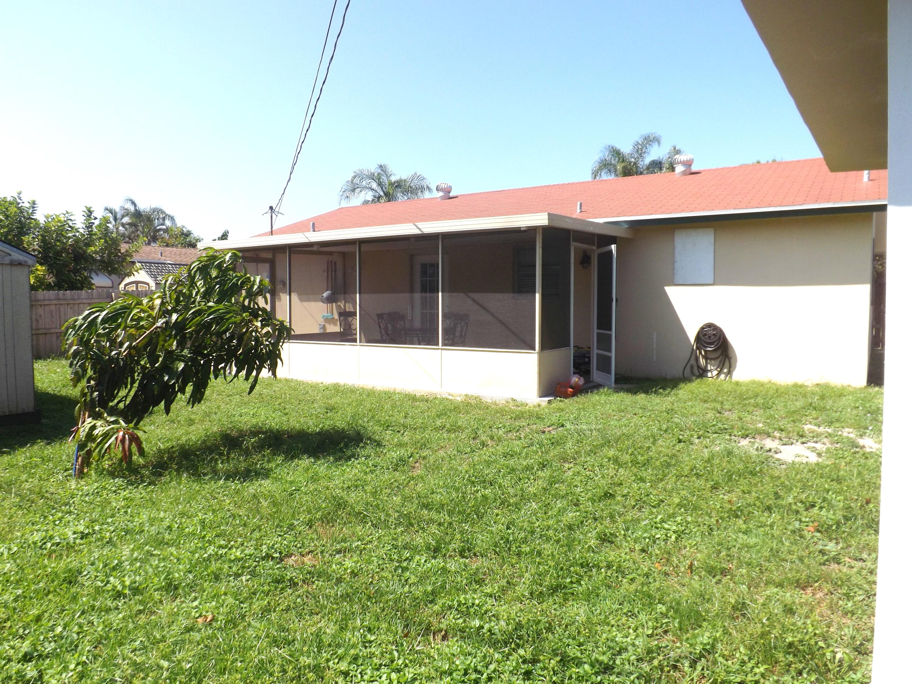 64 Davis Road Palm Springs, FL 33461 - Photo 29 of 32 a view of a house with backyard and a garden