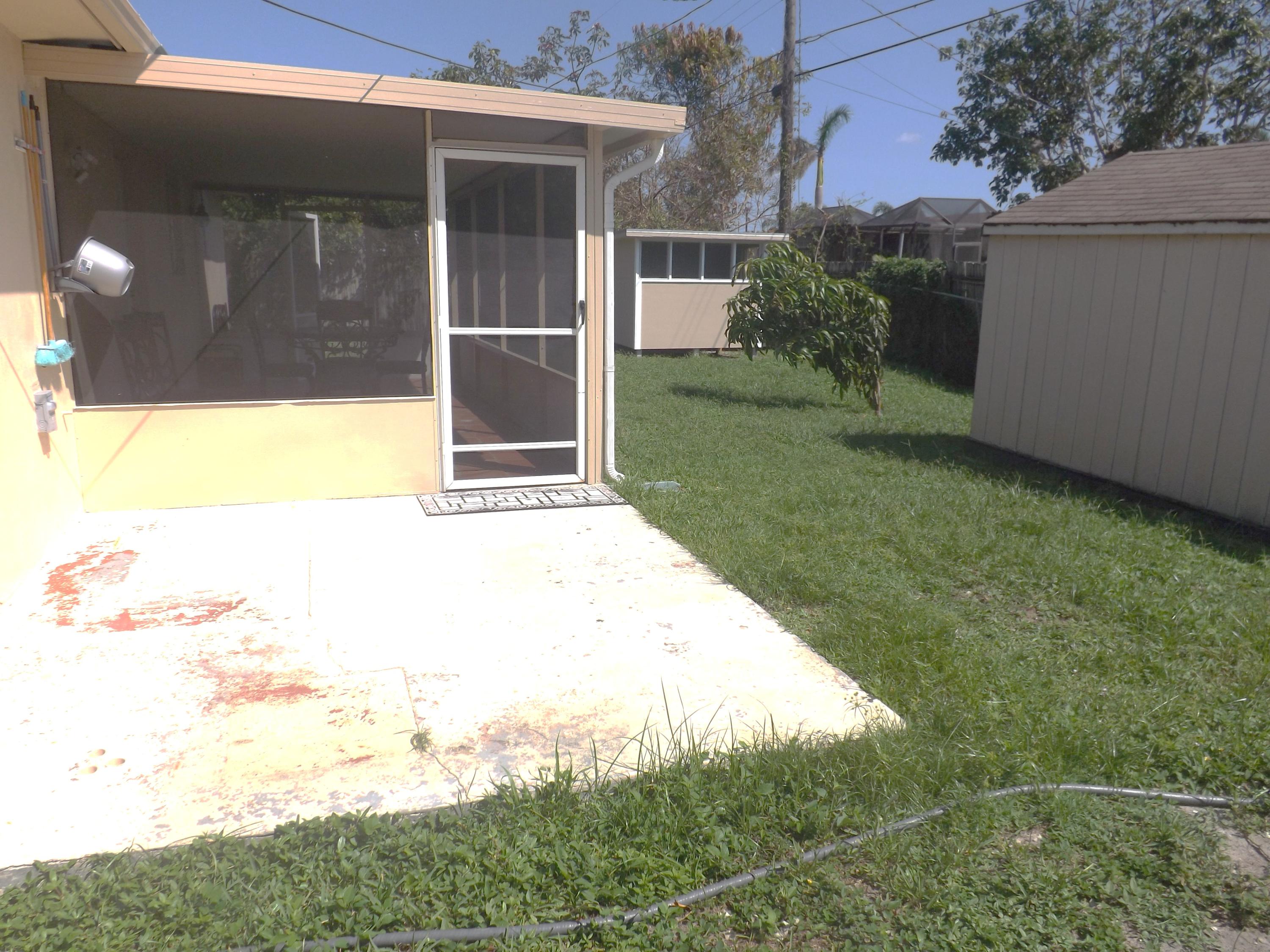 64 Davis Road Palm Springs, FL 33461 - Photo 32 of 32 a view of backyard with potted plants and a bench