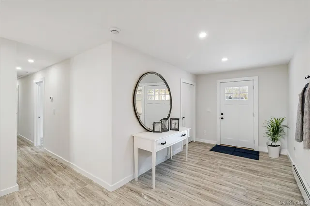 a view of a hallway with wooden floor and a living room