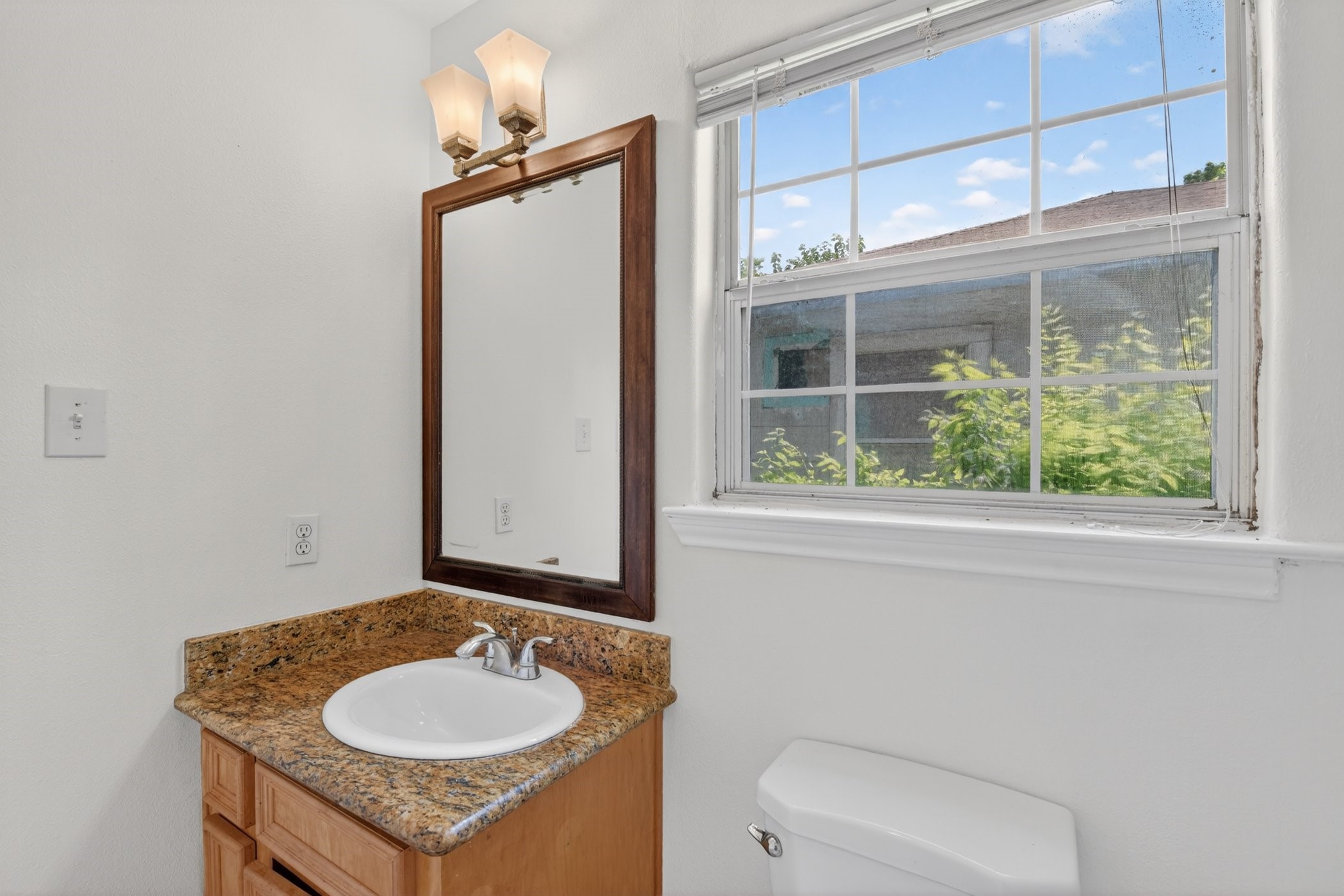 7013 St Augustine Street Houston, TX 77021 - Photo 28 of 35 a bathroom with a granite countertop sink and a mirror