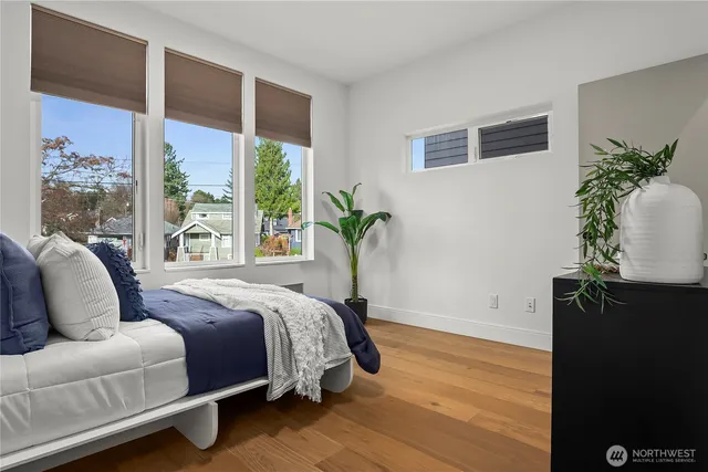 a bedroom with a large bed and a potted plant
