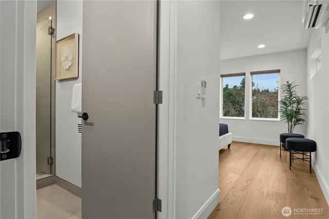 a view of a room with a large window wooden floor and front door