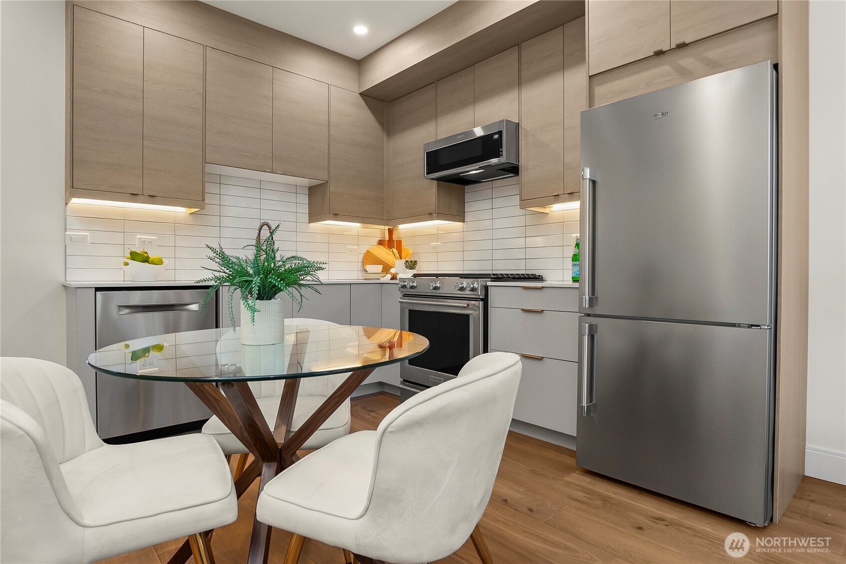 4758 Green Lake Way North Seattle, WA 98103 - Photo 8 of 26 a kitchen with stainless steel appliances granite countertop a dining table chairs and a refrigerator