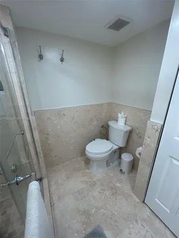 a bathroom with a sink a toilet a mirror and shower