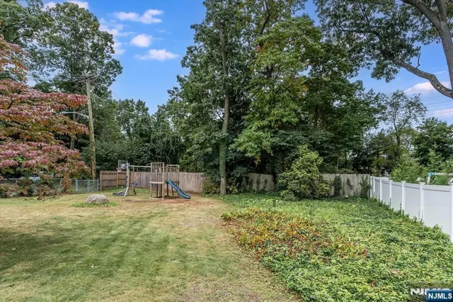 a view of backyard with a barn and large trees