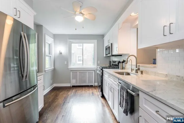 a kitchen with a sink a refrigerator and a stove top oven