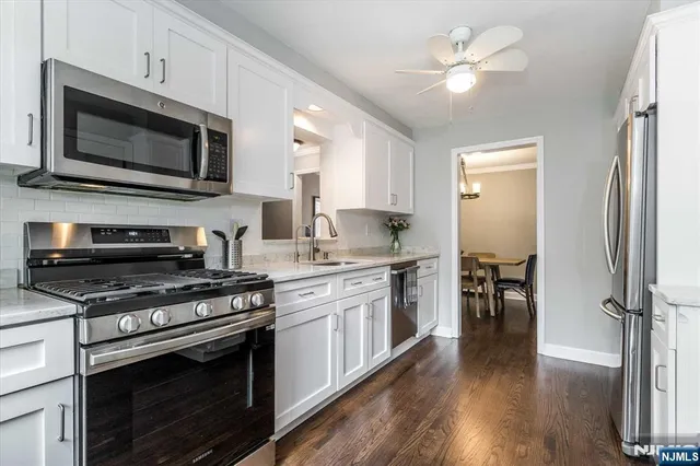 a kitchen with stainless steel appliances a stove a microwave oven cabinets and a refrigerator