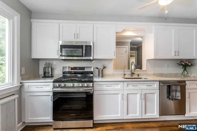 a kitchen with granite countertop white cabinets and appliances