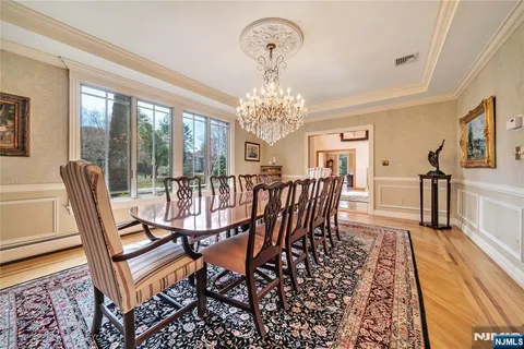 a view of a dining room with furniture a chandelier and wooden floor