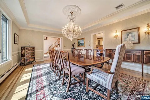 a dining room with furniture a chandelier and wooden floor
