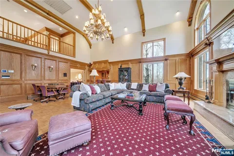 a living room with furniture a chandelier and a rug