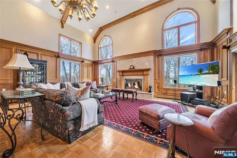 a living room with furniture a chandelier and a floor to ceiling window