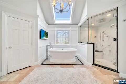 a spacious bathroom with a tub double vanity and a shower