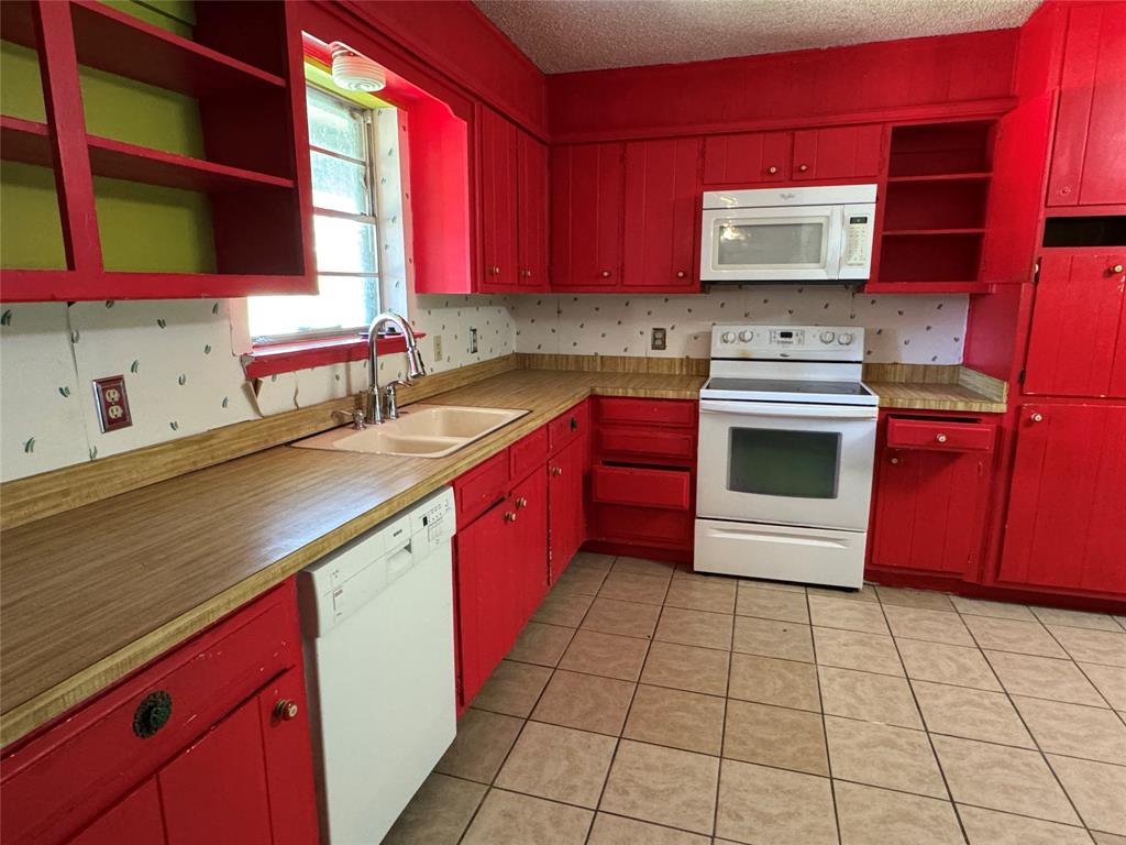 415 Meadowlark Trail Springtown, TX 76082 - Photo 5 of 40 a kitchen with stainless steel appliances a sink a stove and a microwave