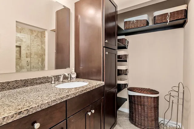 a bathroom with a granite countertop sink and a mirror