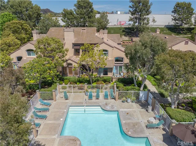an aerial view of a house with a yard potted plants and large tree