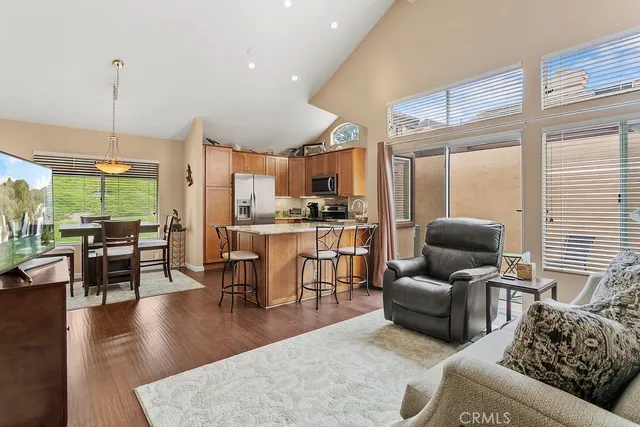 a living room with furniture kitchen view and a large window