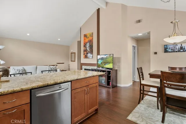 a kitchen with granite countertop a sink cabinets and wooden floor