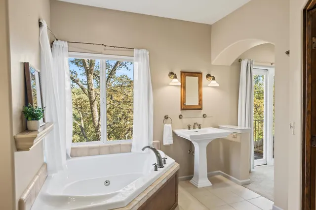 a bathroom with a tub sink and mirror