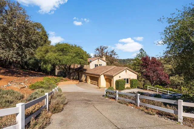 a view of a white house with a yard and sitting area