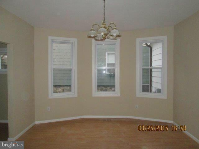 5414 Tramore Road Baltimore, MD 21214 - Photo 5 of 24 an empty room with chandelier fan and windows
