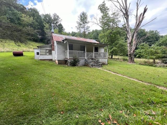 1030 Long Branch Road Green Mountain, NC 28740 - Photo 3 of 16 a front view of a house with a yard and trees