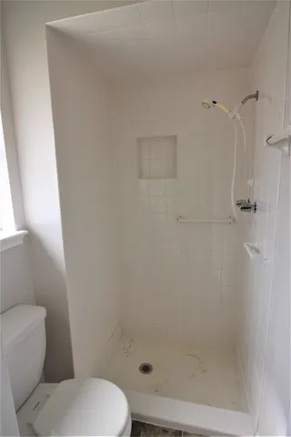 a bathroom with a toilet and a shower