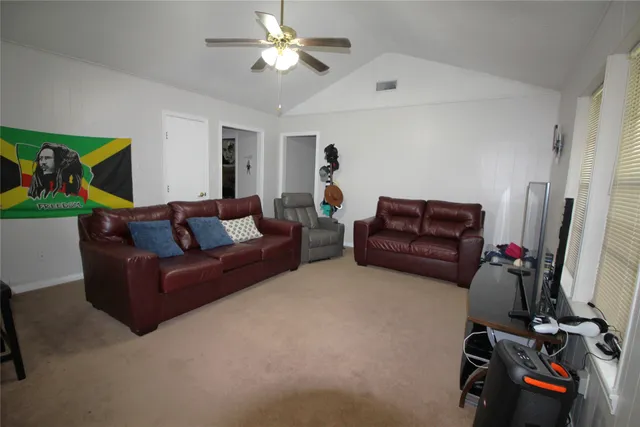 a living room with furniture a flat screen tv and a window