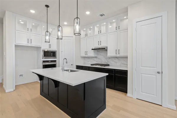 a kitchen with stainless steel appliances granite countertop a sink a stove and a refrigerator