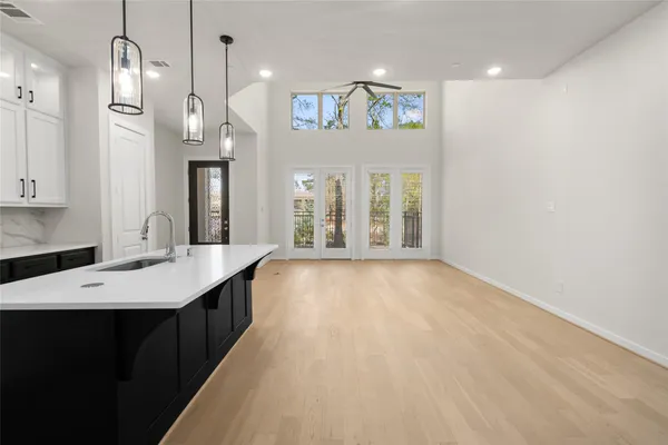 a kitchen with a sink a chandelier and living room