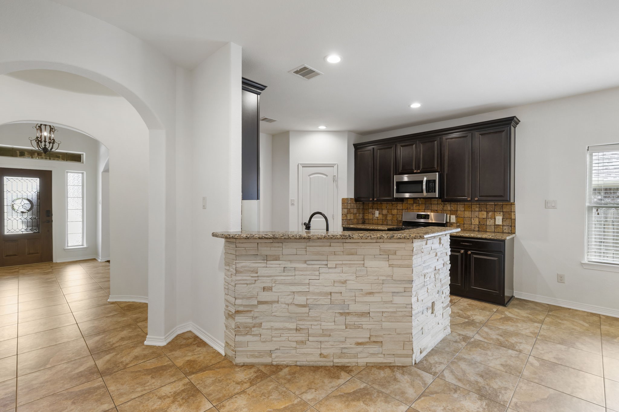 23911 Augusta Falls Lane Spring, TX 77389 - Photo 9 of 40 a large kitchen with kitchen island granite countertop a stove top oven a sink a counter space and cabinets