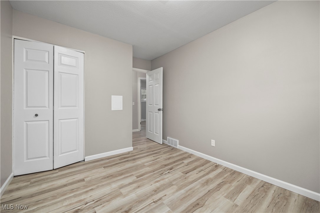 6265 Jaycox Road North Ridgeville, OH 44039 - Photo 30 of 39 Unfurnished bedroom with light wood-style flooring, baseboards, and a closet