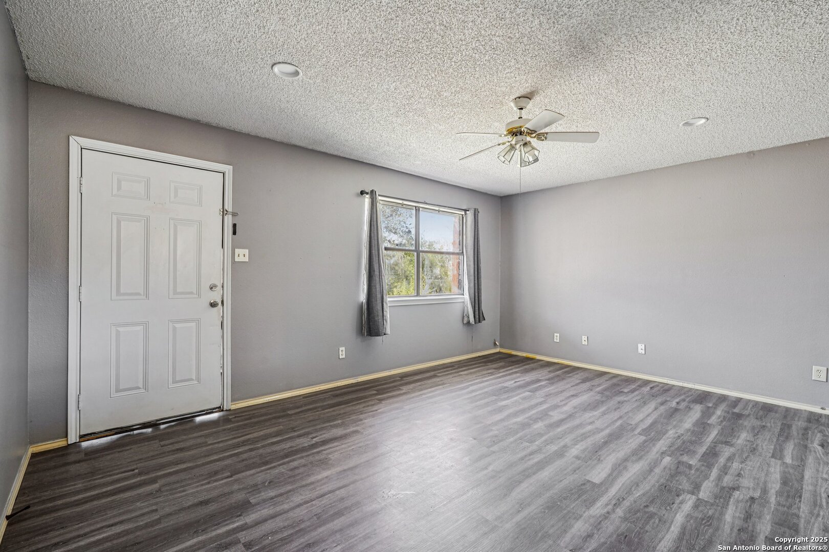1601 Newton Street Kerrville, TX 78028 - Photo 4 of 23 a view of an empty room with window chandelier fan and wooden floor