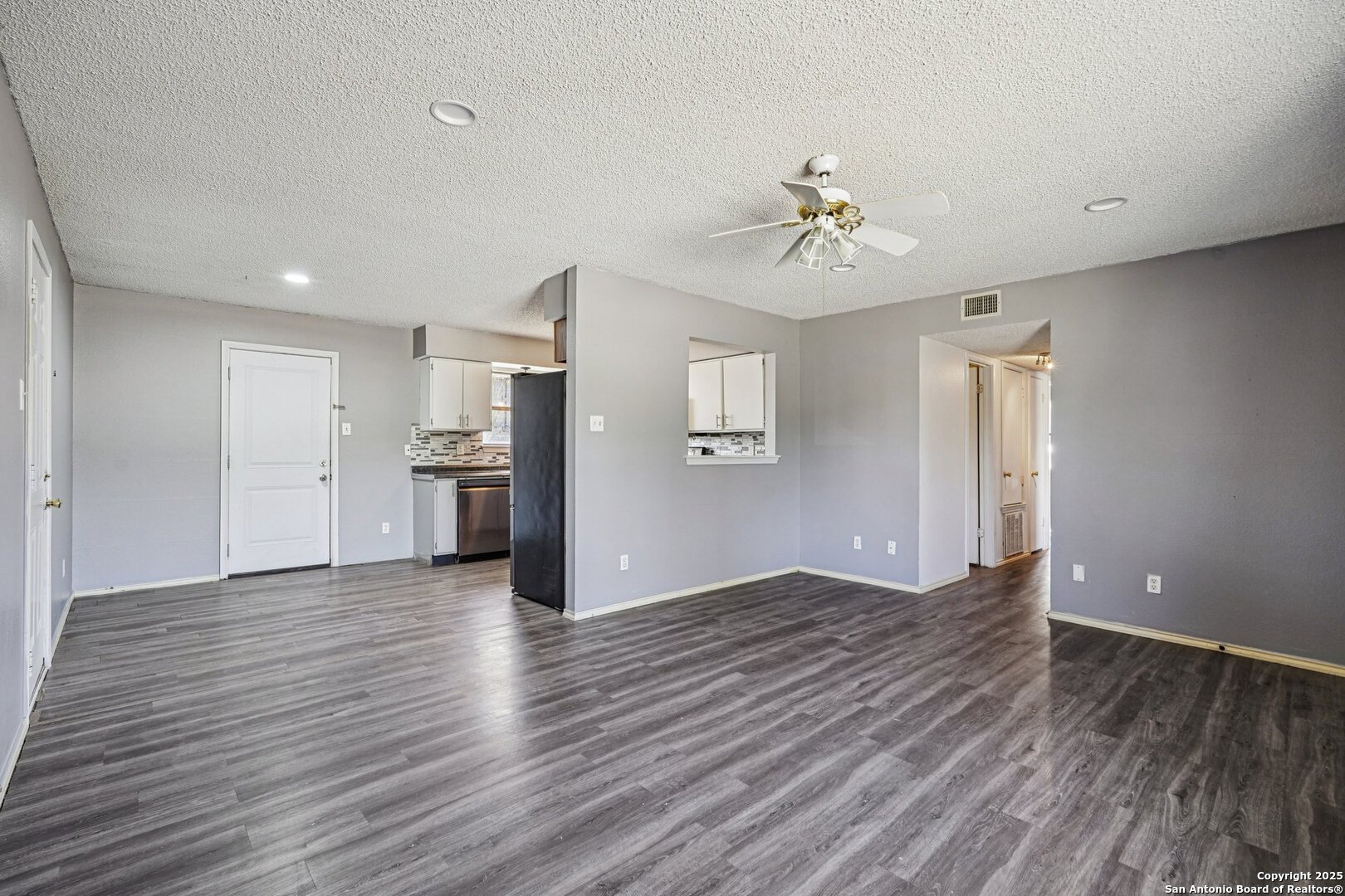 1601 Newton Street Kerrville, TX 78028 - Photo 6 of 23 a view of an empty room with window wooden floor and a kitchen