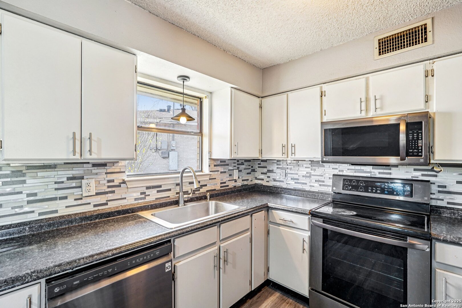 1601 Newton Street Kerrville, TX 78028 - Photo 10 of 23 a kitchen with stainless steel appliances a stove microwave and sink