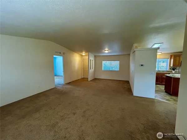 a view of an empty room with a kitchen