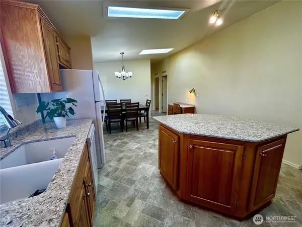 a living room with granite countertop furniture a sink and a refrigerator