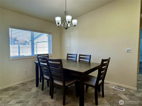 a view of a dining room with a table and chairs