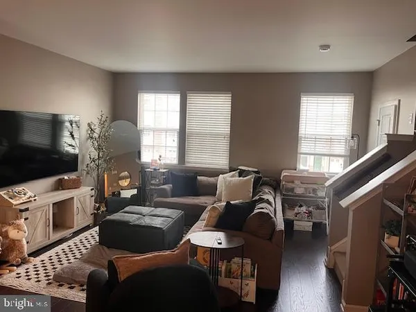 a living room with furniture a flat screen tv and a window