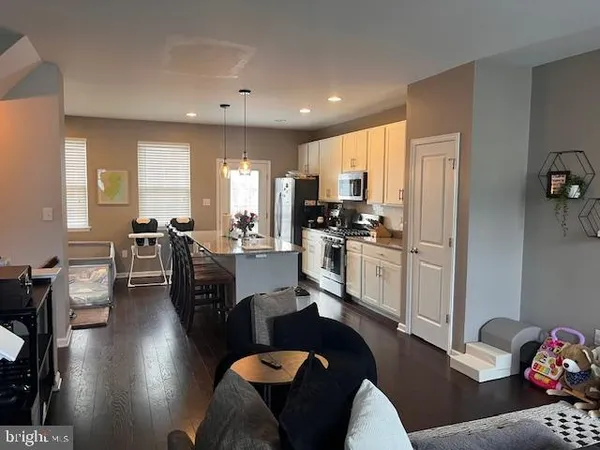 a living room with furniture kitchen view and a refrigerator