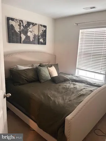 a bed sitting in a bedroom next to a window