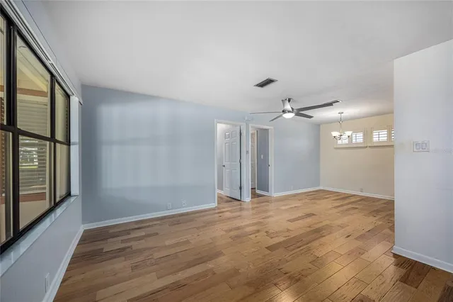 a view of an empty room with glass door and windows