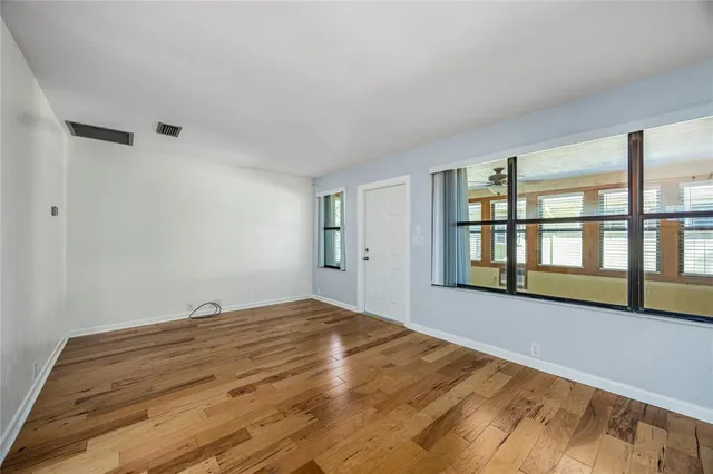 a view of a kitchen with a fridge wooden floor and a ceiling fan