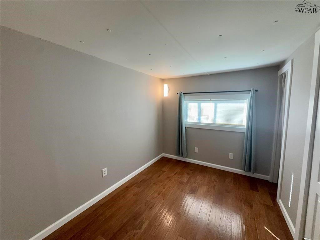 106 Patterson Street Wichita Falls, TX 76301 - Photo 12 of 20 an empty room with wooden floor and windows