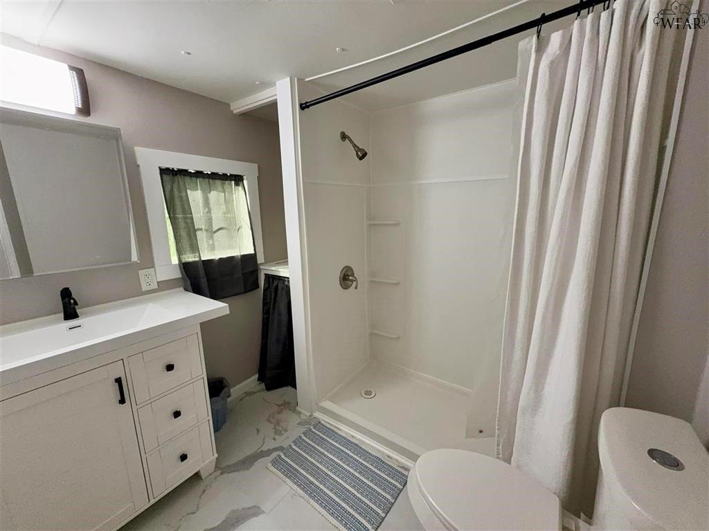 106 Patterson Street Wichita Falls, TX 76301 - Photo 17 of 20 a bathroom with a granite countertop sink toilet and shower