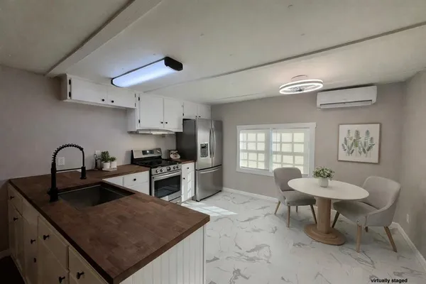 a kitchen with stainless steel appliances granite countertop a sink dishwasher a stove a refrigerator a microwave oven with white cabinets and wooden floor