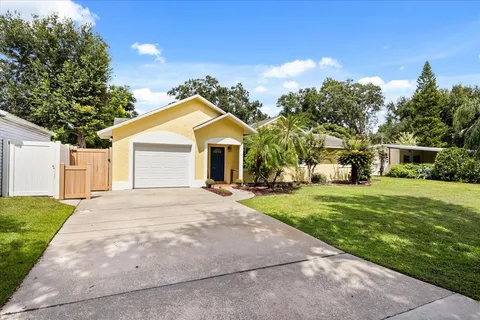 a front view of a house with a yard and trees