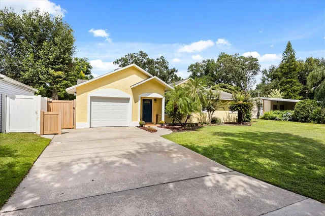 a front view of a house with a yard and trees