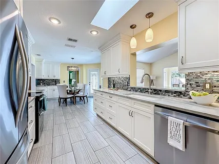 a kitchen with stainless steel appliances granite countertop a refrigerator and a stove top oven