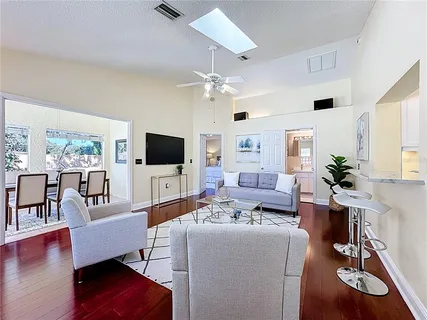 a living room with furniture wooden floor and a flat screen tv
